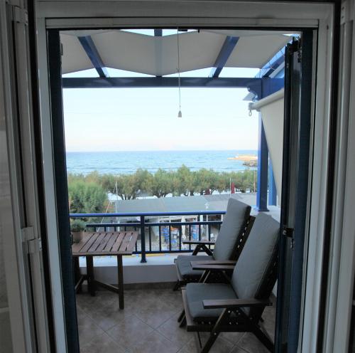 a balcony with chairs and a table and a view of the ocean at Sea Urchin Apartments 2nd floor in Agia Pelagia Kythira