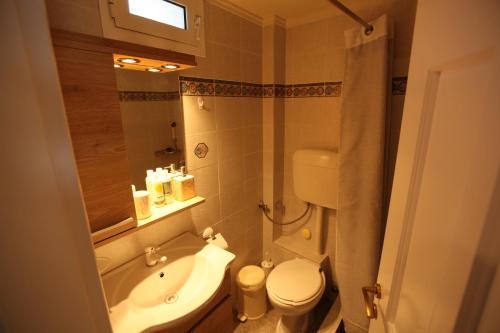 a small bathroom with a sink and a toilet at Sea Urchin Apartments 2nd floor in Agia Pelagia Kythira