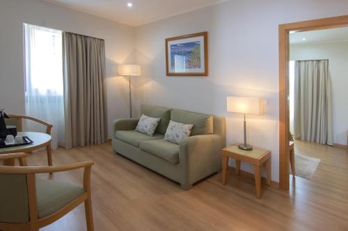 a living room with a couch and a table at Luna Esperanca Centro Hotel in Setúbal