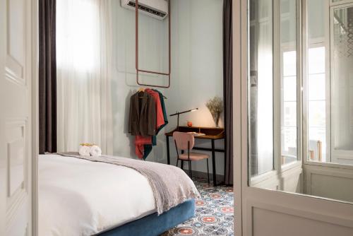 um quarto com uma cama, uma secretária e uma janela em Hotel Lost em Beirute