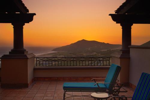a balcony with two chairs and a view of a mountain at Pueblo Bonito Sunset Beach Golf & Spa Resort - All Inclusive in Cabo San Lucas