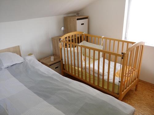 a bedroom with a crib and a bed at Apartma PEPI in Rogaška Slatina