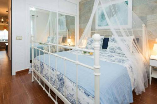 a bedroom with a white bed with a canopy at NORTH CLIFF APARTMENT *The Ocean Beneath your Feet* in Gáldar