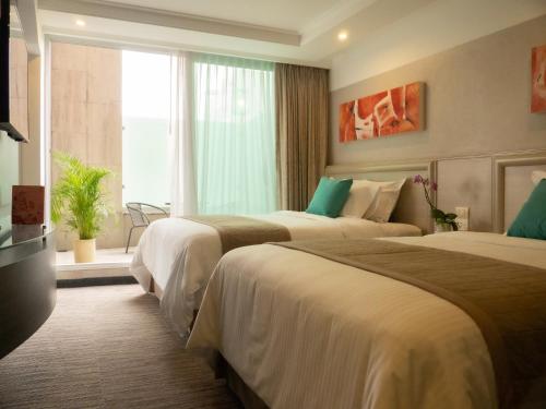a hotel room with two beds and a window at Hotel Marbella in Mexico City