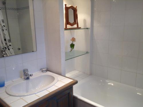 a white bathroom with a sink and a bath tub at Villa L'Adret et sa piscine in Juan-les-Pins