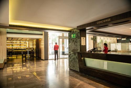 a man standing in the lobby of a building at Hotel Marbella in Mexico City