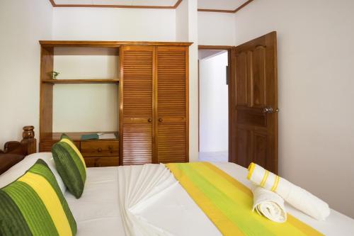a bedroom with a bed and a wooden cabinet at Chez Mera Self Catering in La Digue