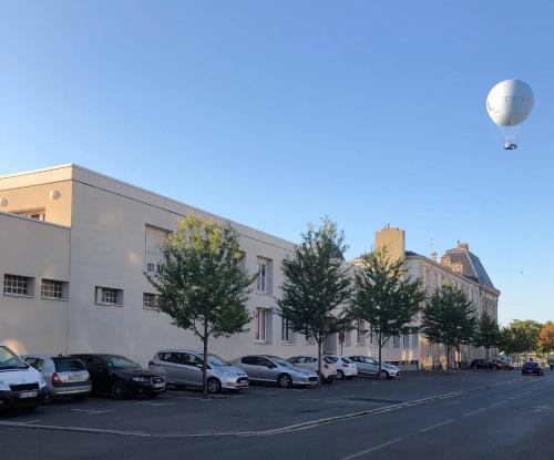 una fila di auto parcheggiate in un parcheggio di Appartement Aventure à Épernay a Épernay