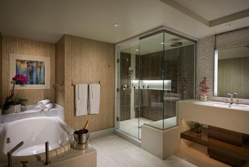 a bathroom with a tub and a glass shower at Seminole Hard Rock Hotel and Casino Tampa in Tampa