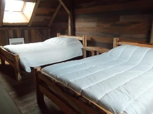 two twin beds in a wooden room with a window at gîte 8 personnes " LE CHAMOIS " in Gerbépal