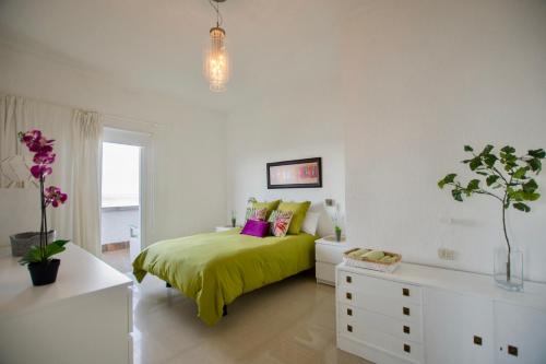 a bedroom with a bed with a green blanket at Apartamento en Playa Chica, Las Gaviotas in Santa Cruz de Tenerife