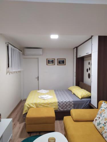 een hotelkamer met 2 bedden en een bank bij T-A APARTMENT in Rijeka Crnojevića