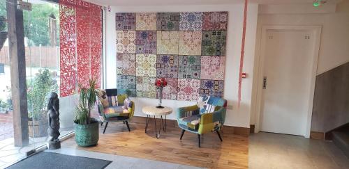 Habitación con sillas, mesa y pared de azulejos. en Stansted Airport Lodge, en Takeley