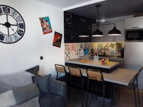 une cuisine avec une table et une horloge au mur dans l'établissement Le Plein Ciel, à Bourg-Saint-Maurice