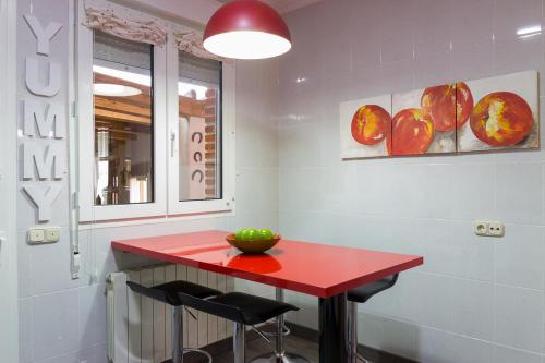 a red table in a room with two stools at Casa Abuela Nila in Cogeces de Iscar