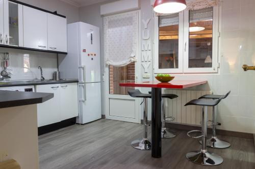 a kitchen with white cabinets and a red counter top at Casa Abuela Nila in Cogeces de Iscar