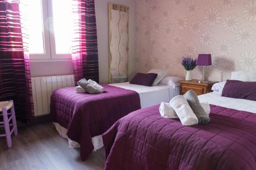 Zimmer mit 2 Betten und lila Bettwäsche in der Unterkunft Casa Abuela Nila in Cogeces de Iscar