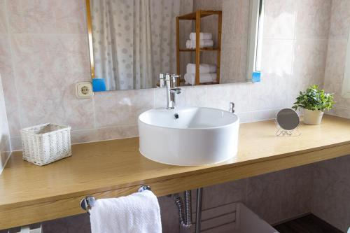 y baño con lavabo blanco y espejo. en Casa Abuela Nila, en Cogeces de Iscar