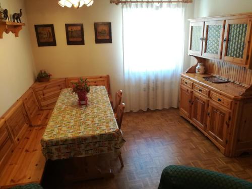 a dining room with a table and a window at Appartamento Paolo in Lavarone