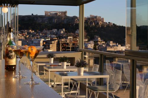 uma varanda com mesas e cadeiras e vista para a cidade em Evripides Hotel em Atenas