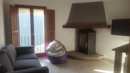 sala de estar con sofá y chimenea en CAL GERARD - ARCAVELL, en Arcabell