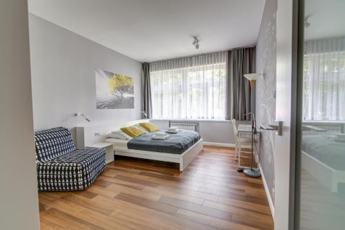 een woonkamer met een bed en een stoel bij Krynica Apartamenty Apartament Słoneczny Deptak in Krynica Zdrój