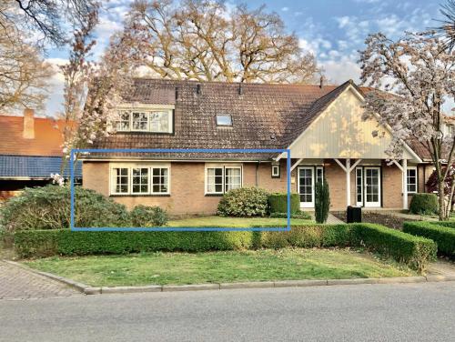 een huis met een blauwe lijn ervoor bij De Bonte Specht in Nijverdal