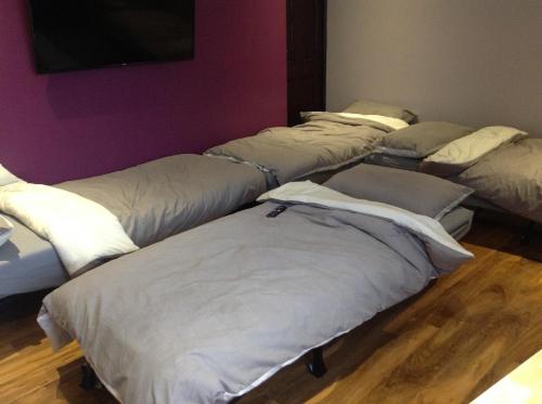 four mattresses lined up against a wall in a room at The Anfield Apartment in Liverpool