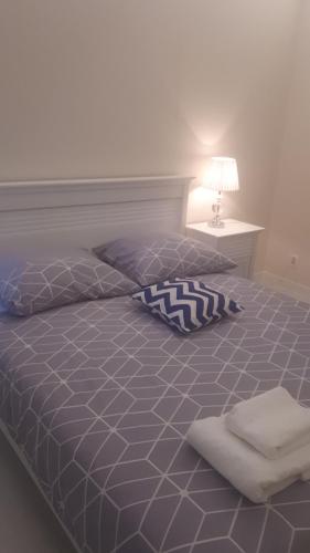 ティヒにあるRegina Luxury Apartamentのベッドルーム1室(青い掛け布団、ランプ付)