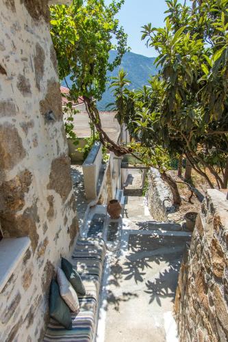a stone wall with benches sitting next to trees at Stairs Homes & Suites in Kamária