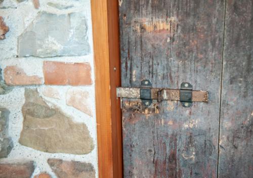 an old wooden door with a stone wall at Terre Di Himera in Buonfornello