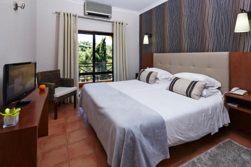 Säng eller sängar i ett rum på Hotel Parque das Laranjeiras