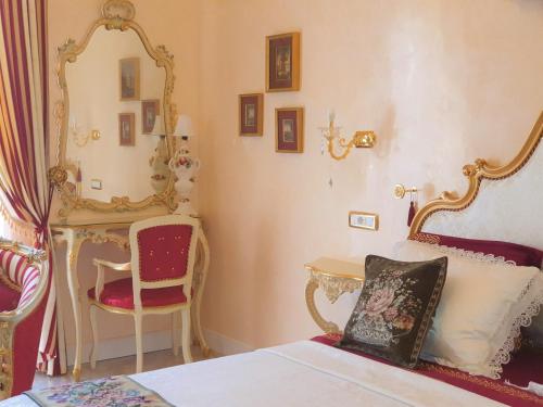 um quarto com uma cama, um espelho e uma cadeira em FD Luxury rooms em Verona