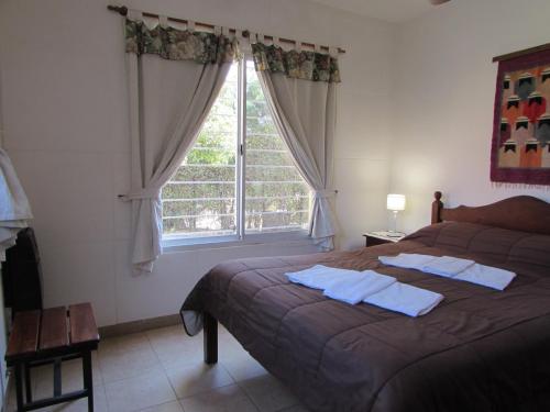 a bedroom with a bed and a large window at Cabañas El Maiten in Merlo