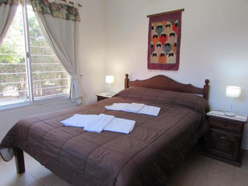 a bedroom with a large bed with towels on it at Cabañas El Maiten in Merlo