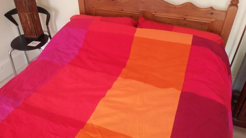 kolorowy koc na łóżku w sypialni w obiekcie The Townhouse w mieście Claremorris