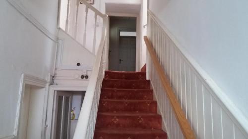 a stairway in a building with a red staircase at The Townhouse in Claremorris