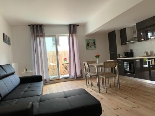 een woonkamer met een bank en een tafel met stoelen bij Attractive modern apartment in Brussel