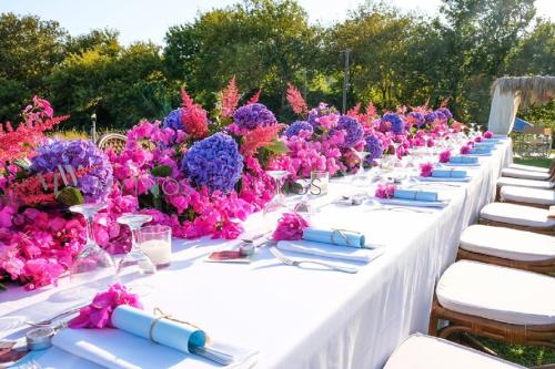 a row of tables with purple and purple flowers at Dreams Apartments - Katelios,Santa Barbara beach in Katelios