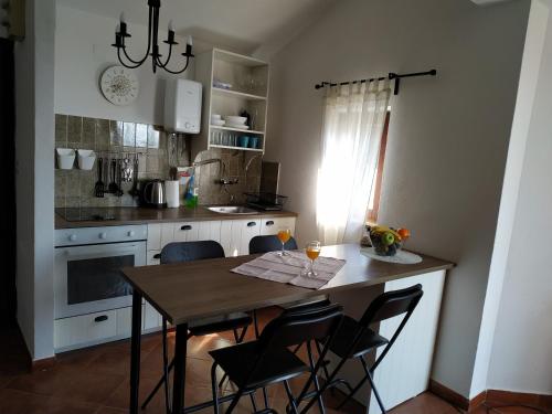a kitchen with a wooden table with chairs and a dining room at Apartments Kupine in Bol