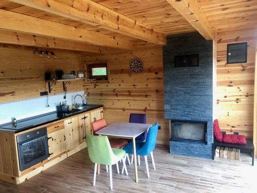 a kitchen with a table and chairs and a fireplace at Zaovinska idila in Bjeluša