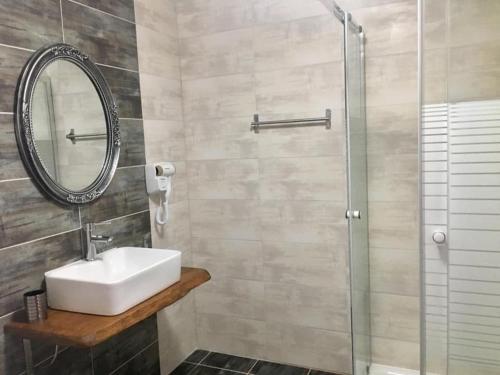 a bathroom with a sink and a glass shower at Almira - rooms to let in Nea Roda