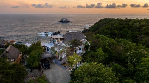 an aerial view of a house on a hill next to the ocean at Casa Kalmar in Zipolite