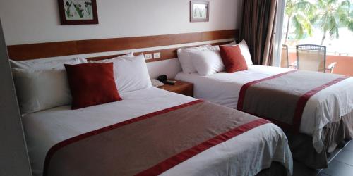 a hotel room with two beds and a window at Peten Esplendido in Flores
