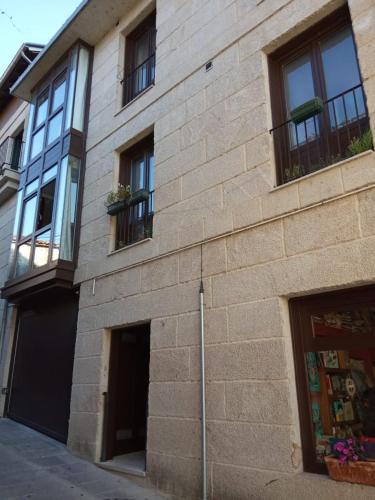 a brick building with windows on the side of it at Apartamento CENTRO HISTÓRICO in Allariz