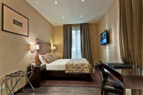 ローマにあるインタウン ラグジュアリー ハウスのベッドとデスクが備わるホテルルームです。