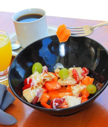 a bowl of vegetables with a fork and a cup of coffee at Yuum Ha Boutique Hotel in Río Lagartos