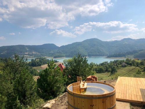 a hot tub with a view of a river and mountains at Zaovinska idila in Bjeluša