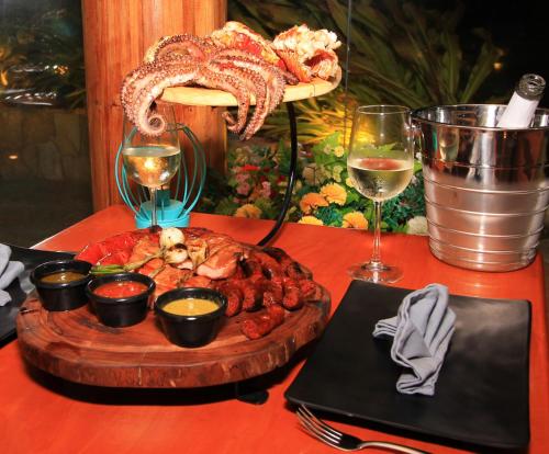 a table with a plate of food and glasses of wine at Yuum Ha Boutique Hotel in Río Lagartos
