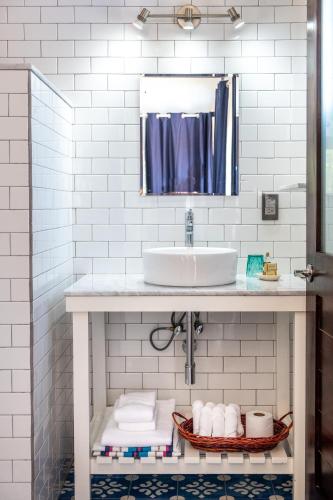 a white bathroom with a sink and a mirror at Casa Kalmar in Zipolite